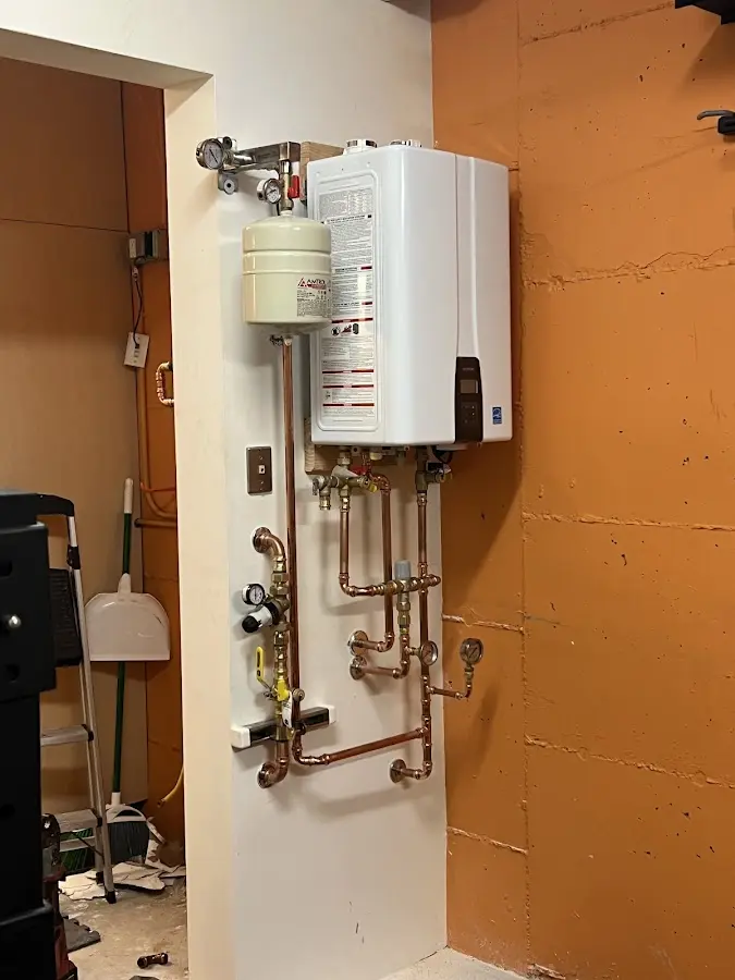 Plumbing technician inspecting water heater connections in Waterloo